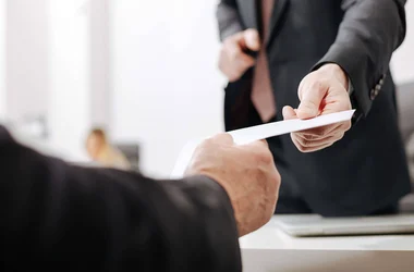 two business professionals exchanging paperwork