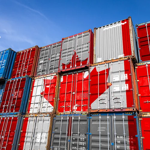 The national flag of Canada on a large number of metal containers for storing goods stacked in rows on top of each other. Conception of storage of goods by importers, exporters