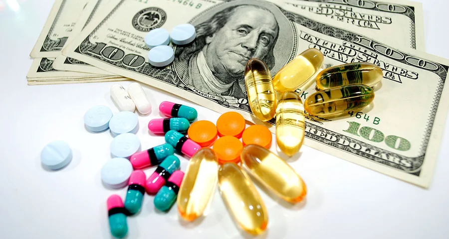 illicit pills sitting on top of a stack of money