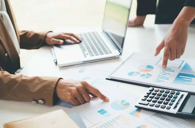 two people going over reports and calculating data