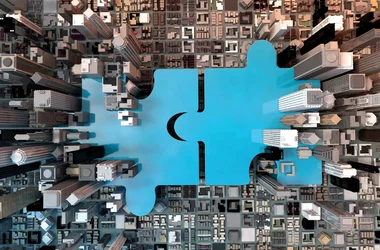 Illustration: Two cities joining together as puzzle pieces.