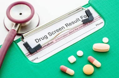 drug test results on a clipboard with pills