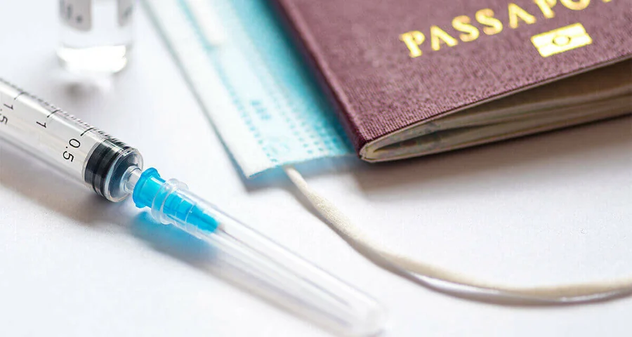 Passport and a vaccination sitting on a table