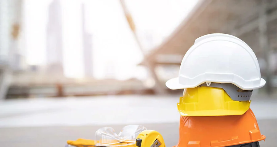 construction hats and safety glasses sitting on a paved surface