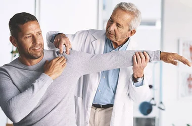 Doctor, man and patient in healthcare for shoulder pain
