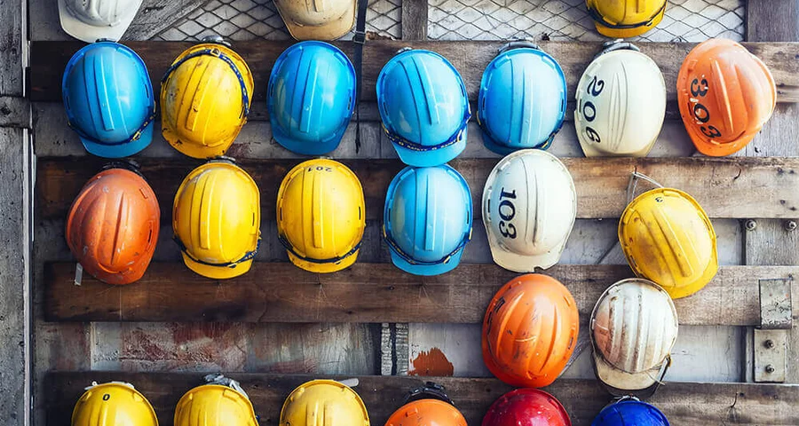 colored hard hats hanging on a wall