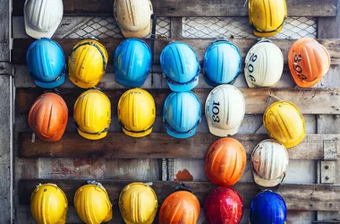 colored hard hats hanging on a wall