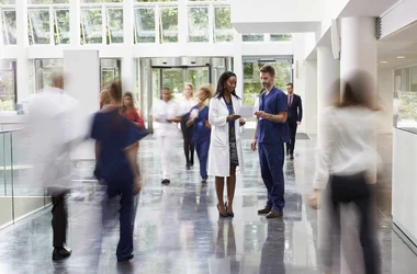 A doctor and a nurse discuss background checks on employees
