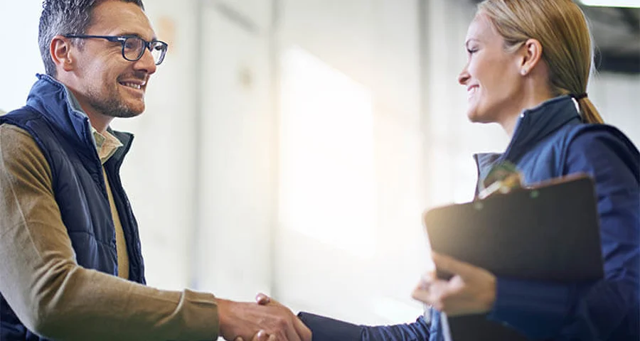 smiling new hire shaking hands with employer