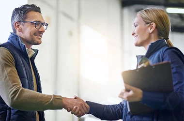 smiling new hire shaking hands with employer