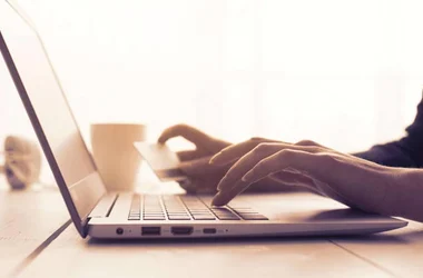 person entering credit card information onto website on laptop