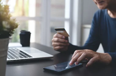 Werkende man checkt creditcard koffie laptop
