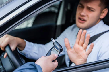 policeman giving breathalyzer to drunk driver showing refuse gesture,