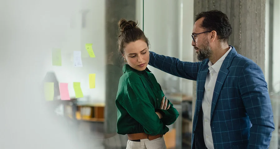 Oncomfortabele foto van een vrouw en een collega die over haar heen staat gebogen