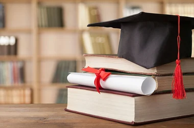 stack of book with a graduation hat and diploma