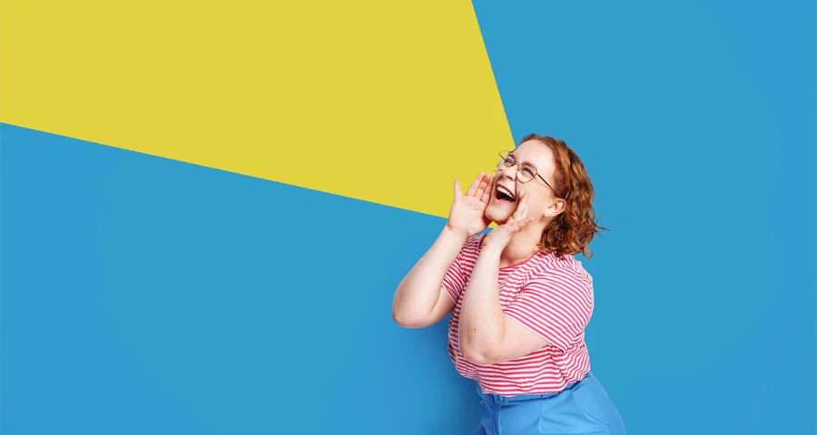 Happy young woman rejoices success isolated blue background