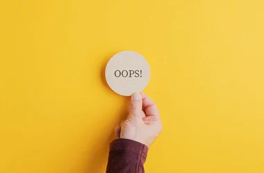 hand picking up a circle with the word "oops"