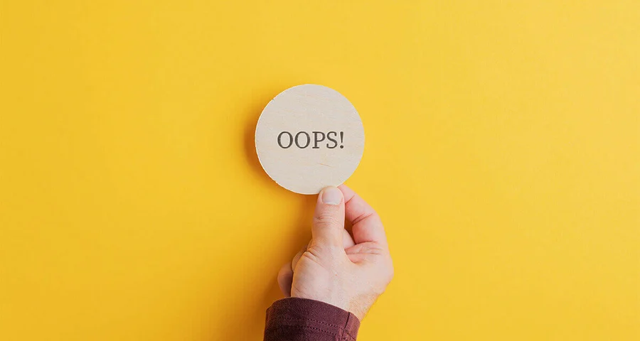hand picking up a circle with the word "oops"
