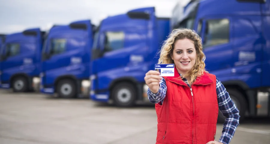 A 21 year old female truck driver holding up her CDL license