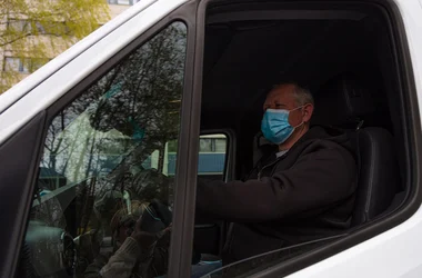 Truck driver behind the wheel wearing a medical mask