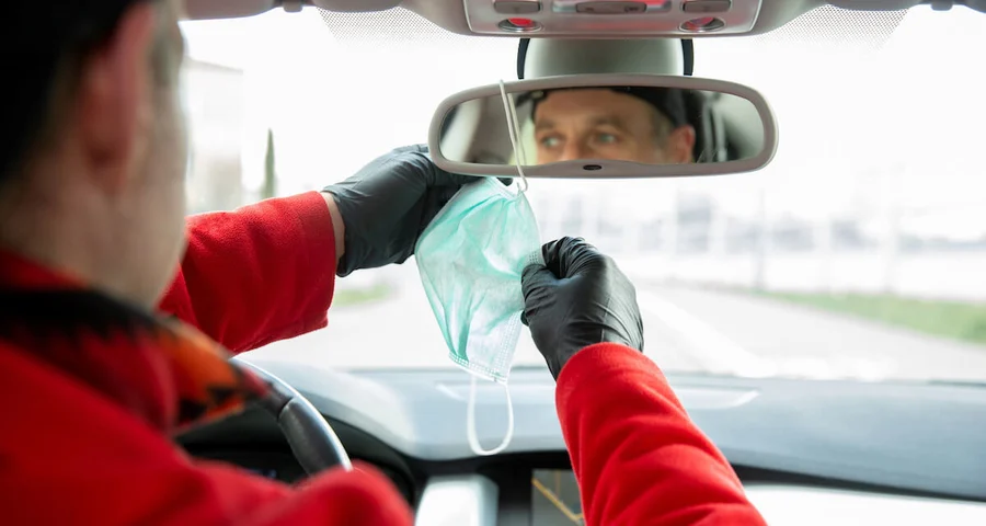 truck driver reaching for face mask