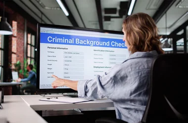 employee viewing criminal background check file on her computer in the office