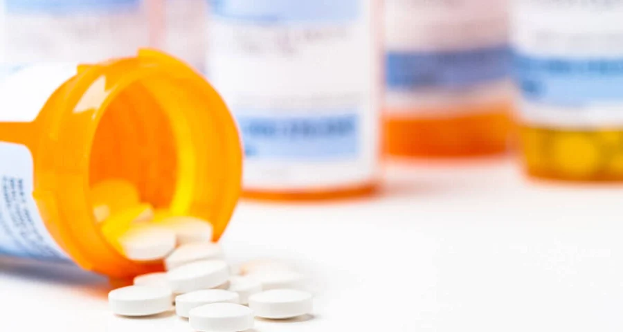 prescription drug bottles pills pouring onto counter