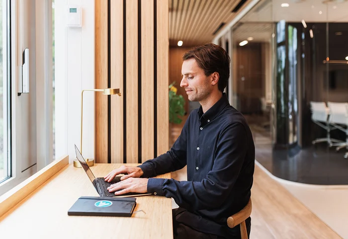 Man som sitter i kontorslokaler och skriver på en dator