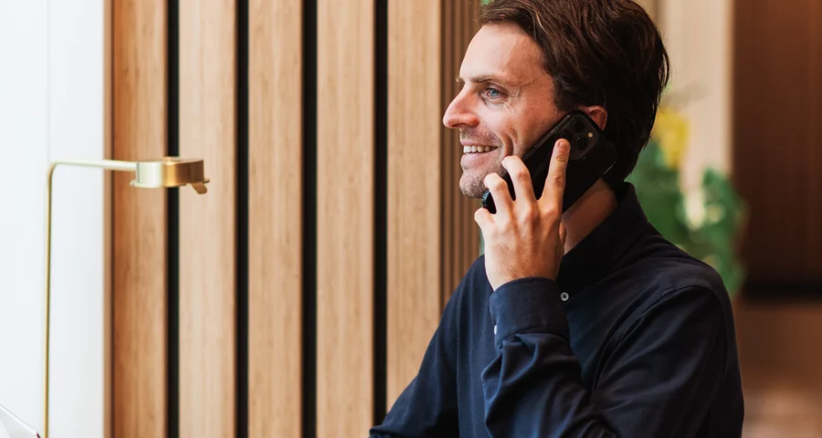 Affärsman som ler på telefonen som validerar och internationell kandidat