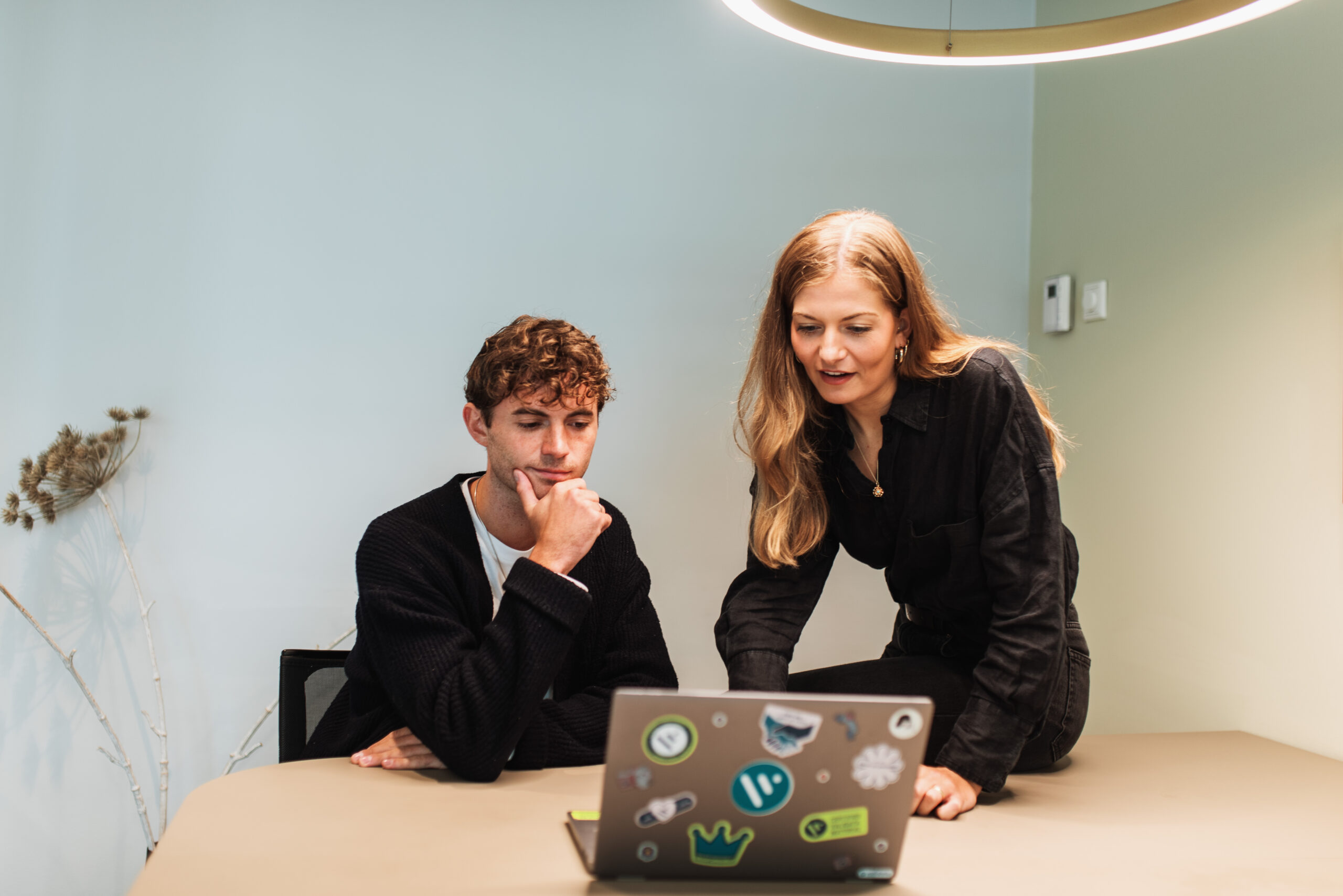 twp coworkers in office viewing laptop