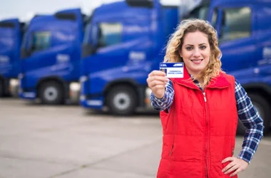 woman truck driver proudly holding commercial driving license