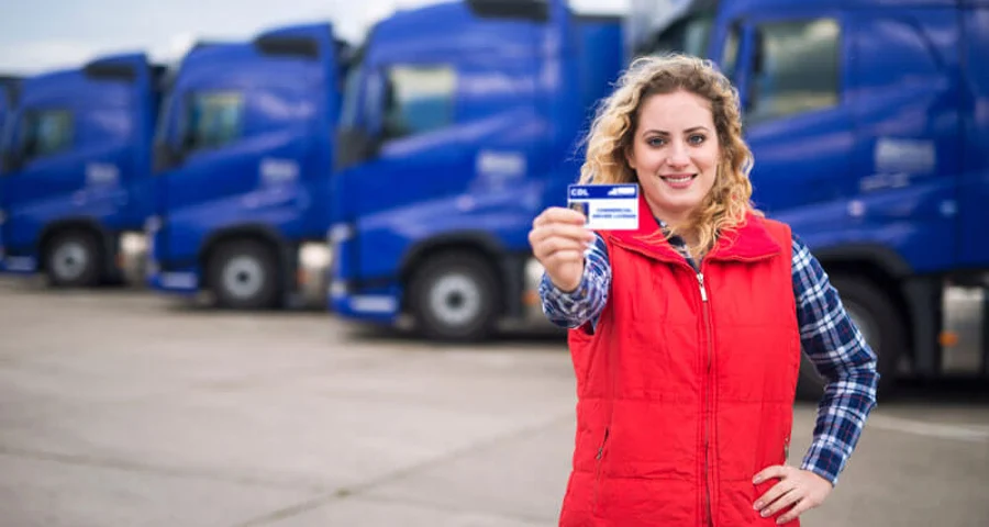 woman truck driver proudly holding commercial driving license