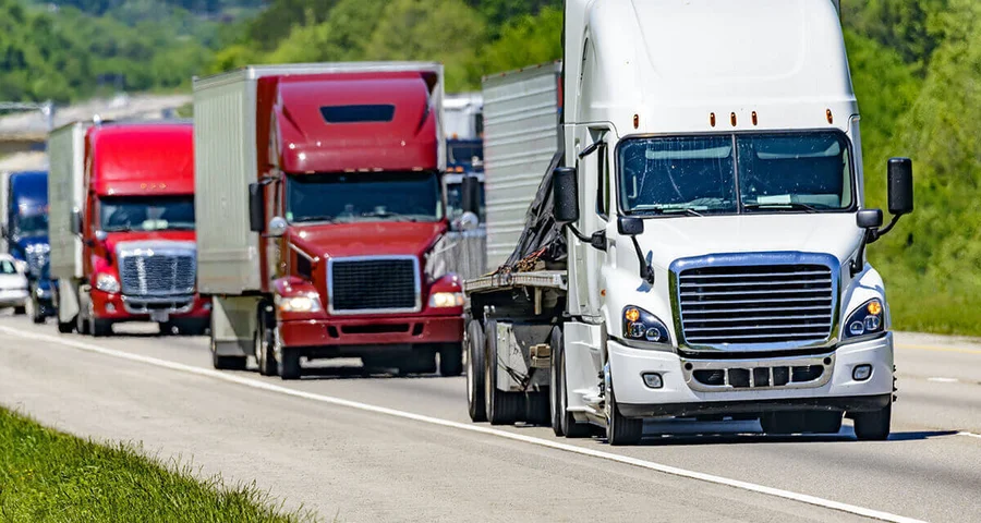 Several 18-wheelers driving on the road