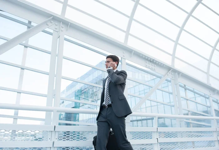 Business man walking in a glass corridor.