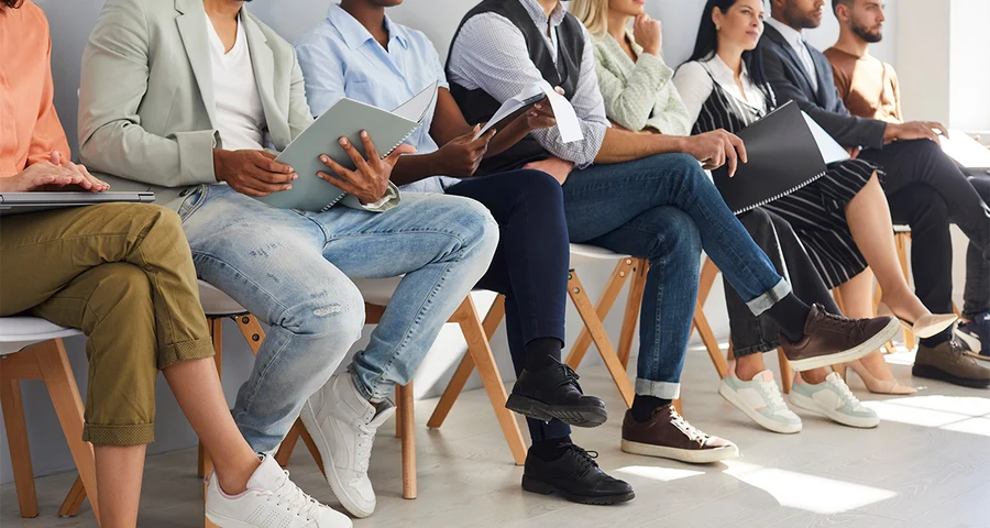 job applicants sitting waiting in line for interviews