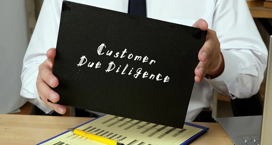 man holding a folder labeled "Customer Due Diligence"