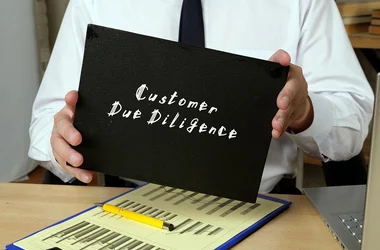 man holding a folder labeled "Customer Due Diligence"