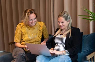 Two colleagues support the screening process on laptop