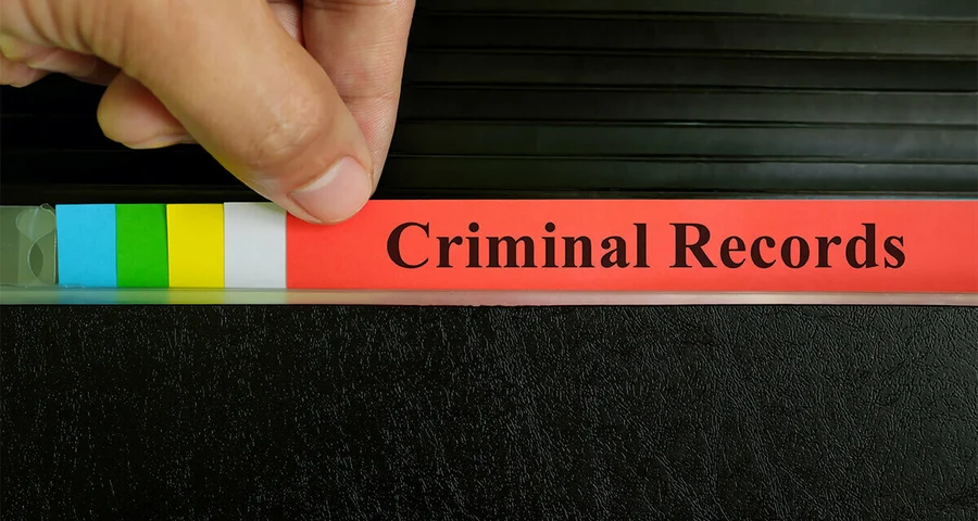 Hand pulling file folders that are titled Criminal Records