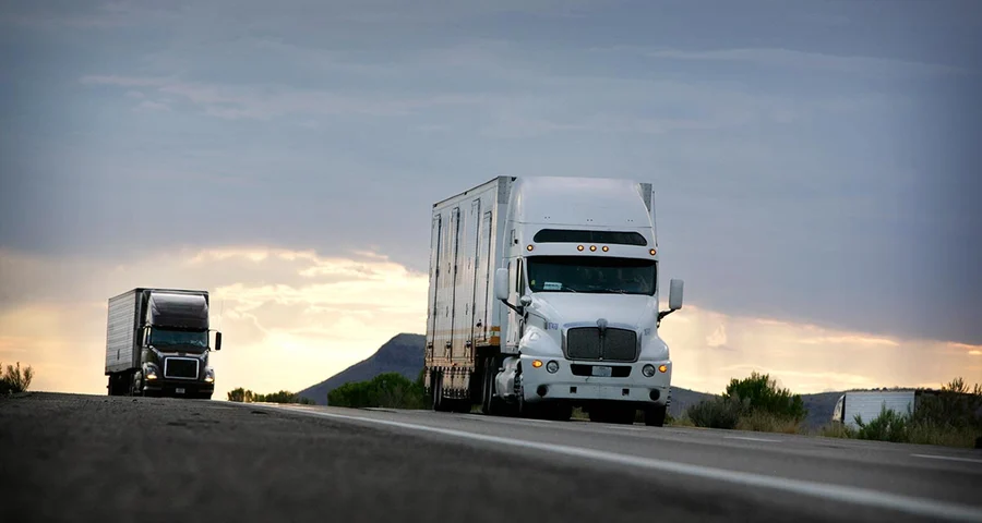 Two long-haul trucks driving on the highway