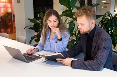 Twee collega's die samen achter de computer werken
