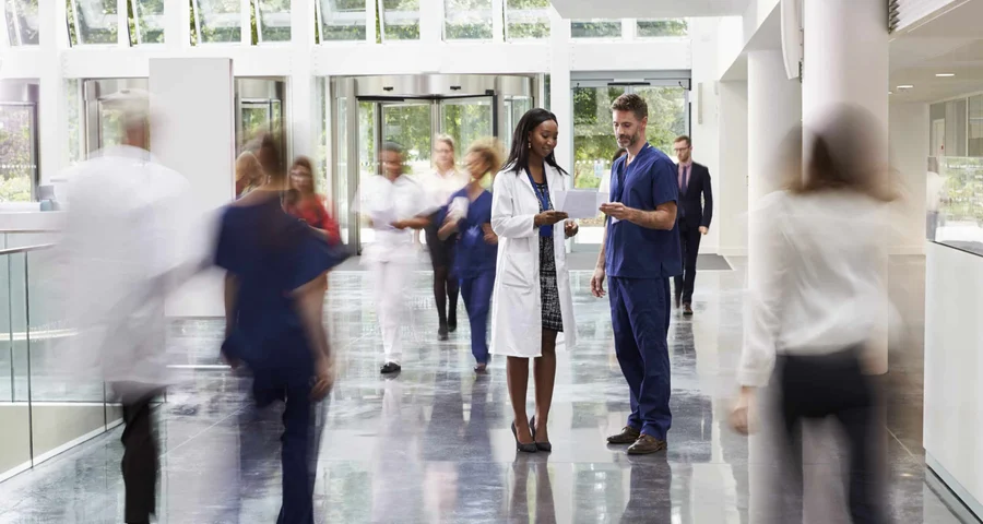 Healthcare workers moving around in a hospital lobby