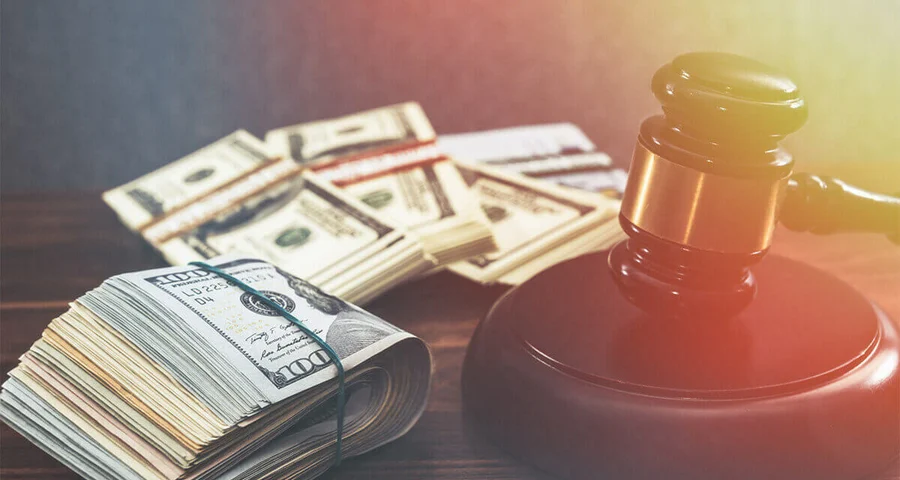Gavel with rolls of money representing fines imposed