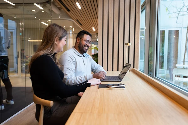 Kvinna och amn sitter vid ett skrivbord och pratar om GDPR och bakgrundskontroller
