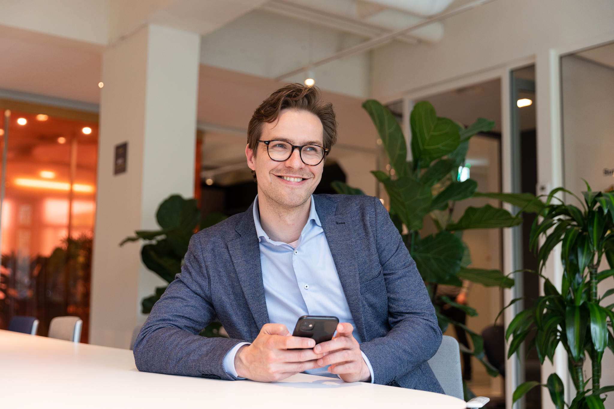 Man i kostym som håller i en mobil