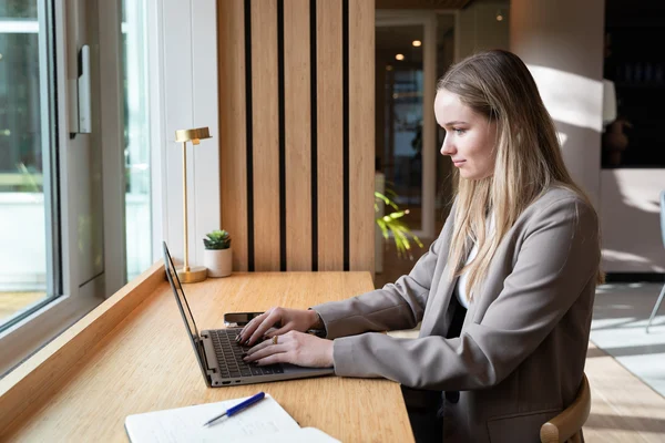 Young woman in a scandinavian office enviroemt sitting in front of a computer