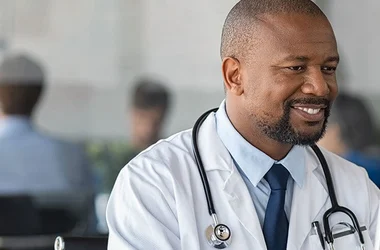 doctor working on a computer and smiling