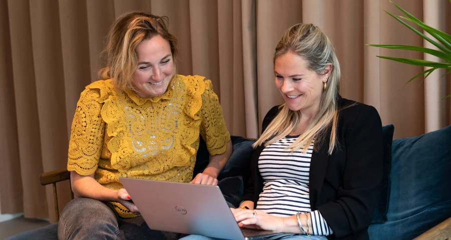Twee collega's ondersteunen bij het screeningsproces op de laptop