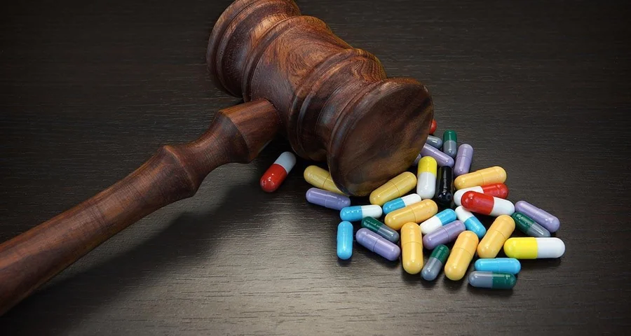 Gavel with a variety of pills on a table