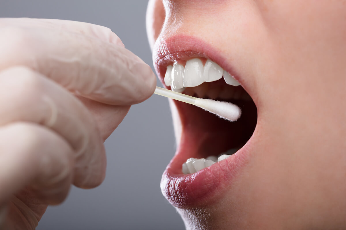 Gloved hand collecting an oral fluid sample